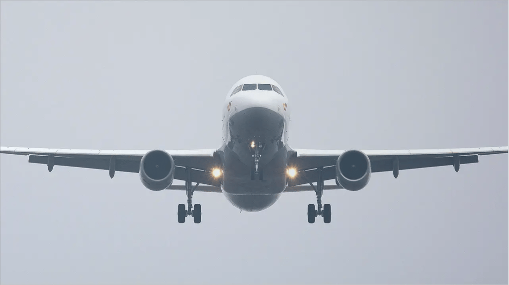 Avión comercial aterrizando en un día nublado, ilustración sobre cuánto cuesta repatriar un cuerpo del extranjero.